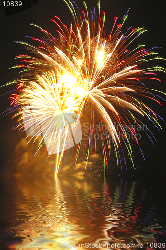 Image of A beautiful fireworks display is captured in Connecticut with billowing smoke and water reflections.