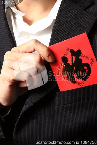 Image of businessman putting chinese cash gift in his pocket