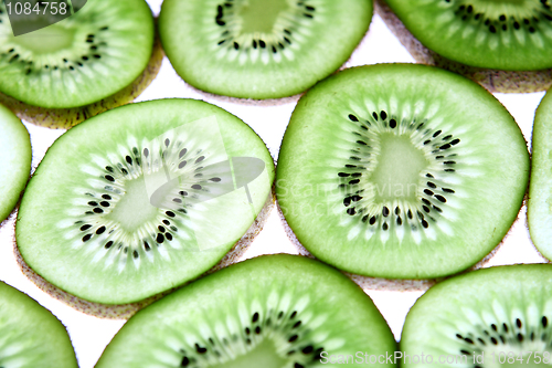 Image of Detail view of kiwi slices backlighted over white background. 