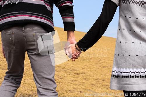 Image of Hand-in-hand. Couple love in autumn scenery 