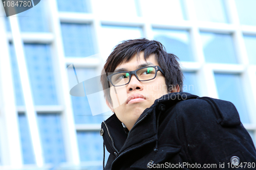 Image of Image of pensive guy looking aside on the background of modern o