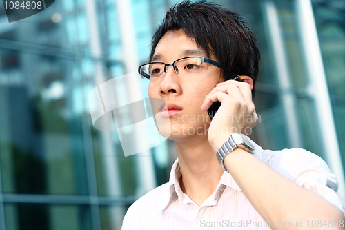 Image of casual asian businessman talking on his cell phone 