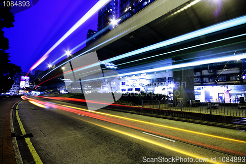 Image of blurred bus light trails in downtown night-scape 