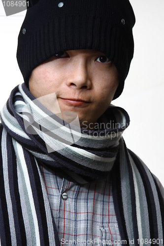 Image of A happy smiling man wearing a hat and scarf posing against white