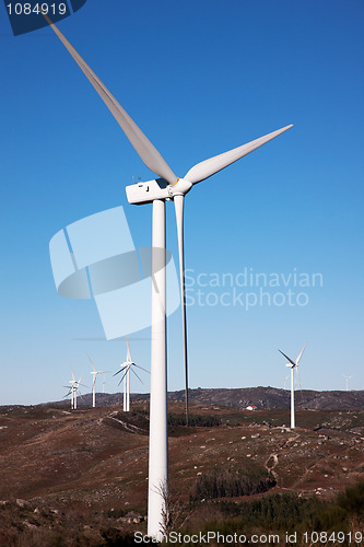 Image of mountain with windmills power, on blue sky;