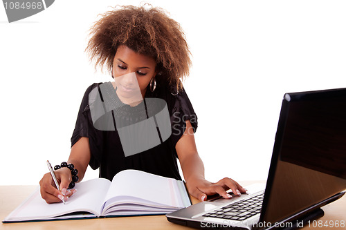 Image of young black women working on desk with computer