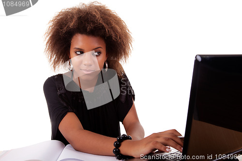 Image of young black women working on desk looking to computer