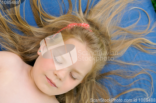 Image of Little girl sunbathing - laying on mattress