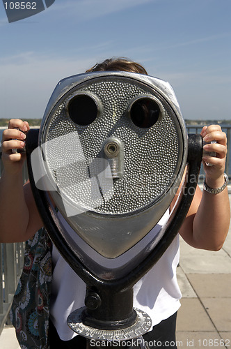 Image of Woman looking through a coin operated binoculars