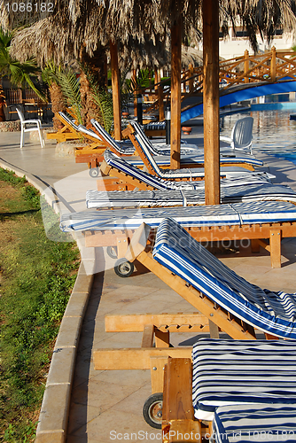 Image of Folding chairs row by swimming pool