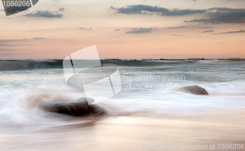 Image of water on rocks at sunset