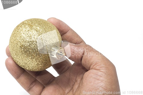 Image of Hand holding a beautiful golden Christmas ball