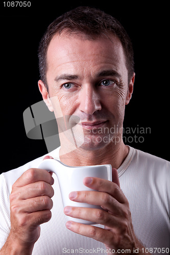 Image of Portrait of a happy man, drinking a drink