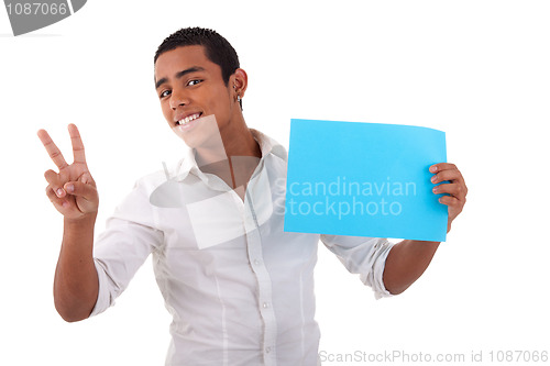 Image of happy young latino man, with blue card in hand, fingers as sign of victory