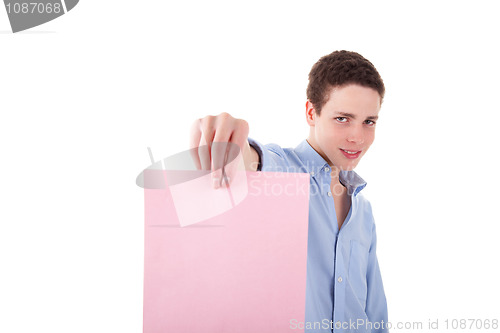 Image of young smiling man holding a pink sheet of paper in his hand