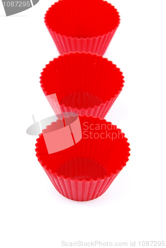 Image of Red plastic cups for small cakes on white