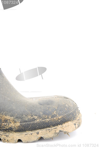 Image of Muddy rubber boot on white