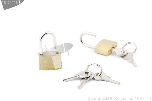 Image of Two golden open padlock with keys on white