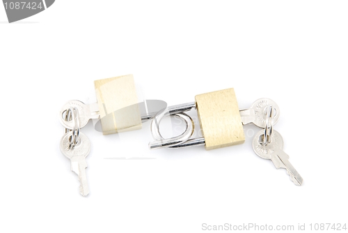 Image of Two golden padlocks and keys on white