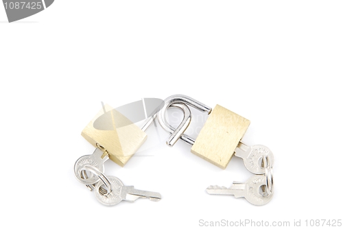 Image of Two golden padlocks and keys on white