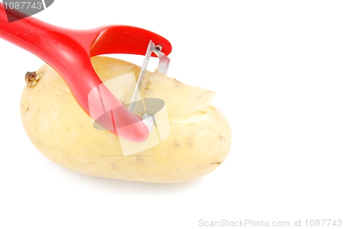 Image of Peeling a potato with peeler on white