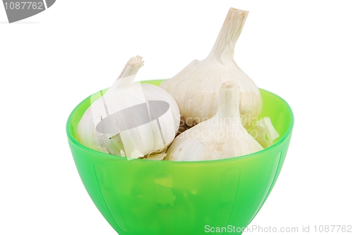 Image of Green bowl of fresh garlic on white