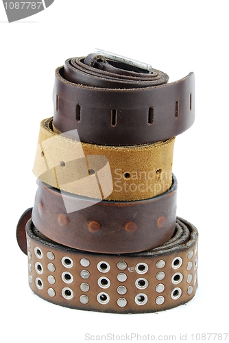 Image of Stack pile of leather belts on white