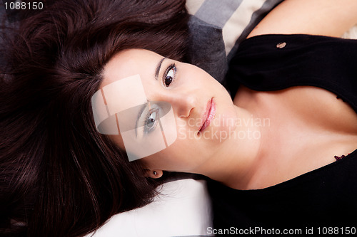 Image of beautiful and smiling middle-age woman lying