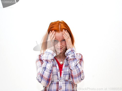 Image of Redhead young woman holding her hand to the head