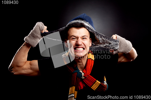 Image of  man in winter clother pulling his furry hat