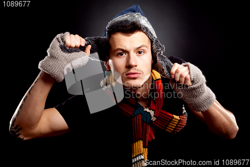 Image of young man holding a furry hat