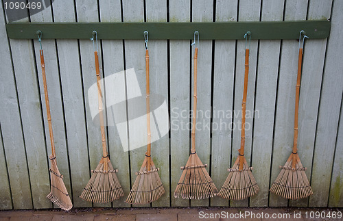 Image of Six bamboo rakes on wall