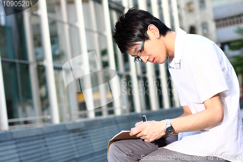 Image of chinese man studing outdoor