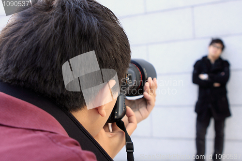 Image of young man photographer doing photos by digital camera 