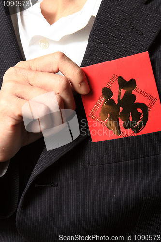 Image of businessman putting chinese cash gift in his pocket