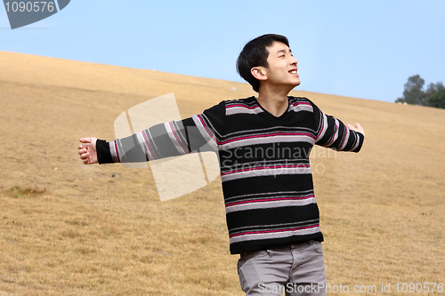 Image of Carefree man standing in golden grass field being happy enjoying