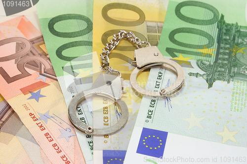 Image of handcuffs on euro notes