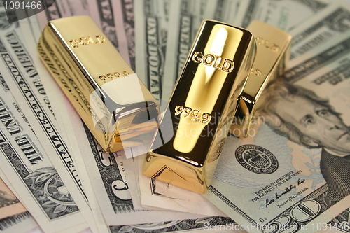 Image of three gold bars on dollar bills