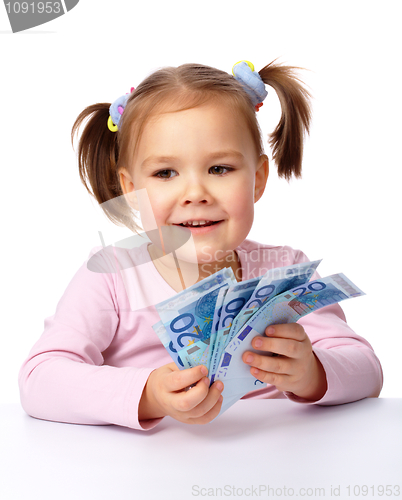 Image of Little girl with few paper euro banknotes