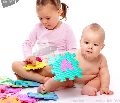 Image of Little boy and girl are playing with alphabet