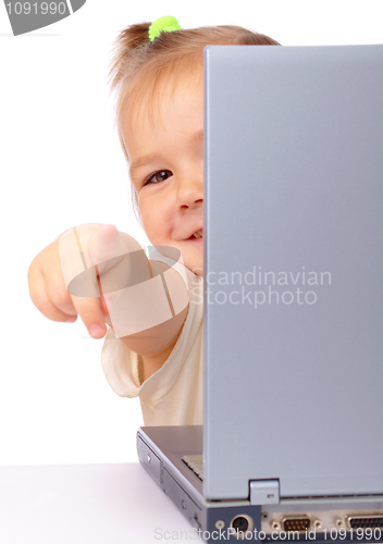 Image of Cute little girl is looking out from her laptop