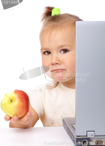 Image of Cute little girl with laptop and apple