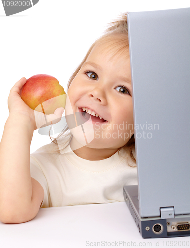 Image of Cute little girl with laptop and apple