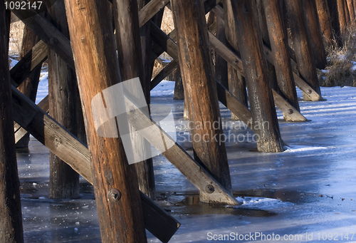 Image of Wooden railroad trestle across a frozen river