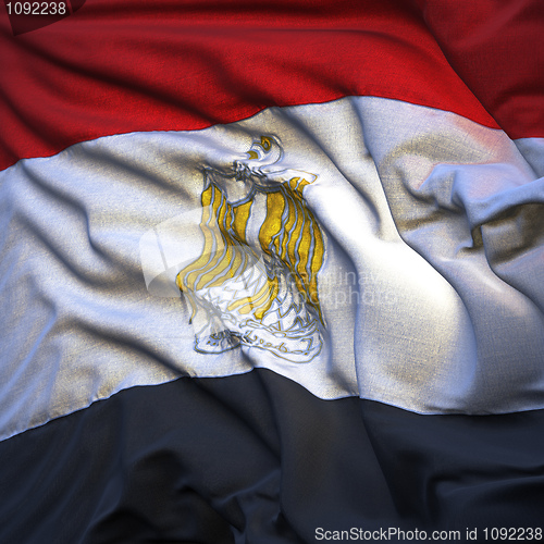 Image of Flag of Egypt, fluttering in the breeze, backlit rising sun