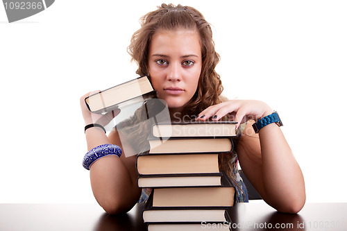 Image of serious and beautiful girl , with a stack of books