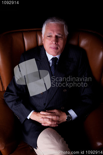 Image of Pensive mature businessman seated on a chair