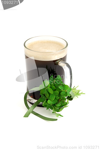 Image of Dark beer in glass and bouquet of false shamrock with green ribb