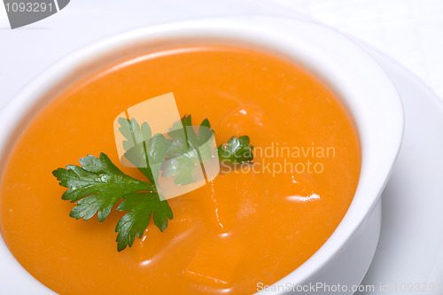 Image of Pumpkin soup in white bowl  with parsley