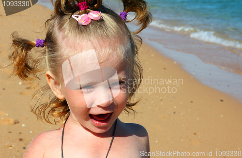 Image of happy little girl on sand beach